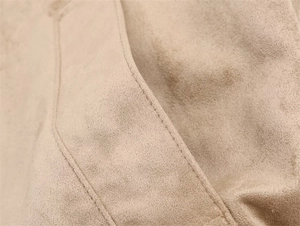 Detailed close-up of high-quality suede jacket stitching and soft fabric texture