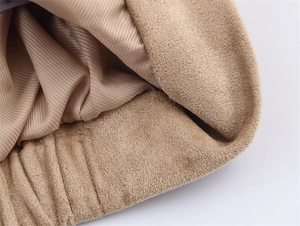 Detail of faux suede fabric and striped satin lining on beige jacket waist