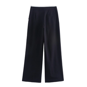 Dettaglio dei pantaloni neri a gamba larga da donna con vita bianca a contrasto e tasca posteriore