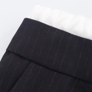 Dettaglio dell'elastico in vita con cuciture su pantaloni scuri a righe sottili