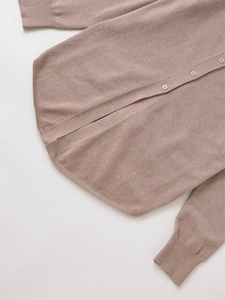 Detailansicht der khakifarbenen Strickjacke mit Rippbündchen und geknöpftem Rundsaum
