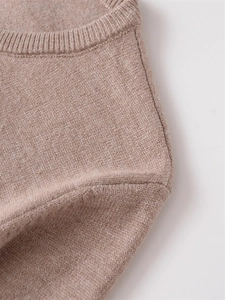 Detailaufnahme der beigen Strickjacke mit geripptem Rundhalsausschnitt und weicher Textur