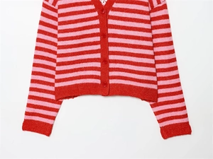 Gros plan sur le gilet en maille rayé rouge et rose avec détail de fermeture à quatre boutons