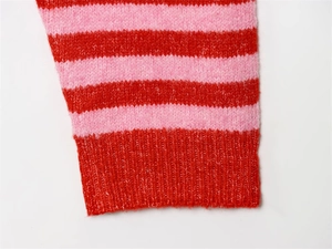 Gros plan d'un cardigan à rayures rose et rouge avec poignets côtelés et maille douce