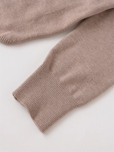 Detailaufnahme der gestrickten Rippbündchen an einem khakifarbenen Langarm-Strickcardigan