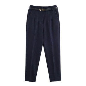 Dettaglio dei pantaloni blu navy a vita alta con pieghe e cintura con fibbia dorata