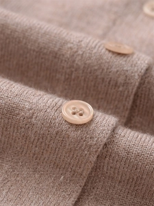 Detailaufnahme des hafermehlfarbenen Strick-Cardigans mit Harzknöpfen und feiner Textur