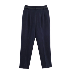 Dettaglio dei pantaloni a vita alta blu navy con cintura nera e pieghe stirate