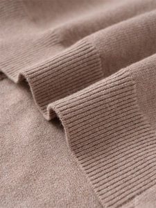 Nahaufnahme der hochdichten Rippstrick-Struktur und weichem Wollstoff in Camel-Braun