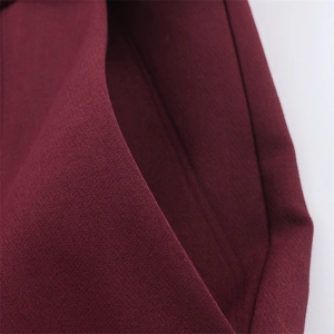Dettaglio macro della tasca dei pantaloni bordeaux con trama tessuta e cuciture piatte