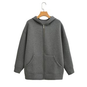 Detail of dark gray oversized hoodie featuring metal zipper and ribbed cuffs on white background