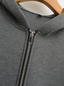 Detail of dark grey heather knit hoodie featuring a metallic silver zipper and soft hood