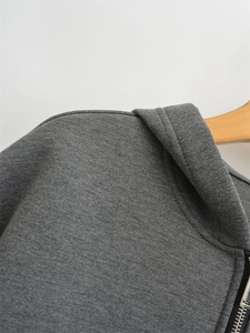 Detail view of smooth metal zipper and fleece fabric texture on gray hoodie