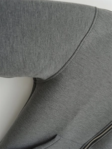 Close-up of high-quality dark gray heather texture fabric with premium metal zipper detail