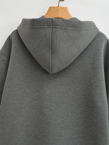 Detail view of the back of a charcoal grey oversized hoodie with a minimalist soft texture