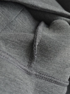 Macro shot showing high-quality stitching and fabric texture on a charcoal grey hoodie
