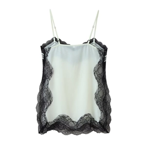 Detail of white camisole top featuring contrast black lace trim and slim straps