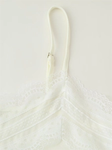 Detail of white lace camisole showing delicate embroidery and adjustable shoulder strap