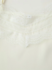 Close-up of cream lace trim and woven fabric detail on a slim-fit women's top size S