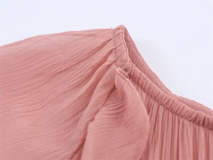 Detail of pink chiffon dress showing ruffled edges and textured elastic stitching