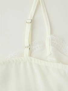 Close-up of adjustable strap buckle and delicate lace detail on the cream camisole top