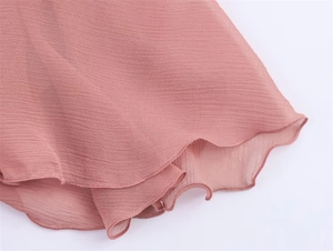 Close-up of pink chiffon dress hem showing fine crepe texture and wavy lettuce edge