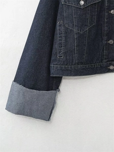 Dettaglio della giacca di jeans indaco con taschino sul petto e bottoni in metallo