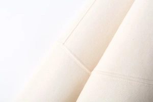 Close-up of premium cream cotton fabric with precise double-needle stitching detail