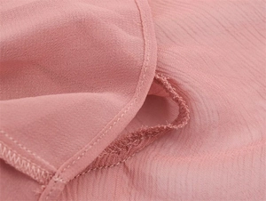 Macro shot of pink chiffon fabric texture and high-quality hem stitching on the dress