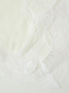 Close-up of elegant white lace floral patterns and smooth satin fabric detail