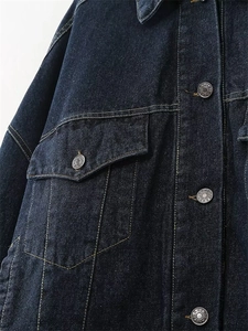 Vista macro dettagliata del tessuto denim blu scuro con cuciture gialle e bottoni metallici