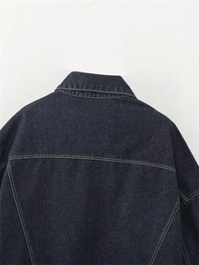 Dettaglio del retro della giacca in denim blu scuro con cuciture a contrasto gialle