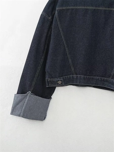 Vista dettagliata della giacca in denim indaco con trama twill e fibbie in metallo