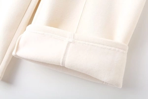Detail of warm off-white fleece lining and precision stitching on casual pants