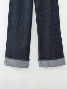 Dettaglio di jeans dritti blu scuro con ampi risvolti e trama in twill di cotone