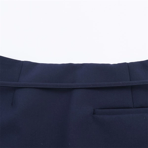 Vista macro della vita dei pantaloni a gonna blu navy con cintura e tasca a filetto