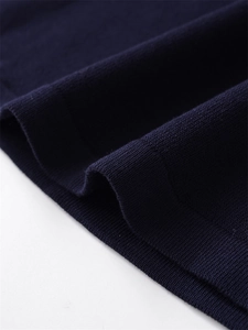 Vista macro del tessuto in maglia blu scuro con cuciture precise sull'orlo