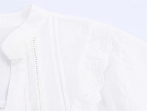 Detail der weißen Bluse mit Spitzenstickerei, Biesen und kleinem Stehkragen