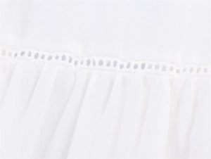 Detailansicht der weißen Bluse mit Leiter-Spitzeneinsätzen und feiner Plissee-Struktur