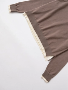 Détail du pull en maille marron avec poignets et ourlet côtelés de couleur crème contrastée