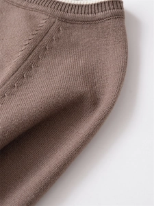Détail d'un pull marron en maille torsadée avec col côtelé et texture de laine