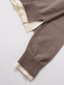 Détail de maille superposée marron et beige avec poignets côtelés et coutures fines