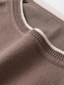 Détail d'un haut en maille marron avec encolure côtelée contrastée de couleur crème