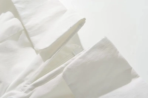 Detail shot of the hidden zipper closure on a white square neck French dress