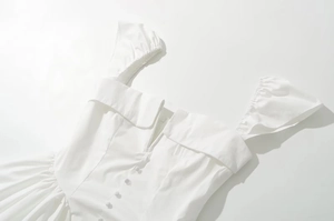 Detail of square neck and decorative buttons on a white French retro A-line dress