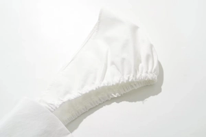 Detailed close-up of white puff sleeve with elastic gathered cuff and woven fabric texture
