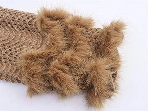 Detail der braunen Strickstruktur mit Wellenmuster und flauschigem Kunstpelzbesatz