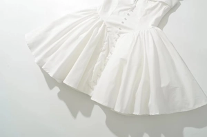 Detail of white square neck mini dress with button front and pleated A-line skirt