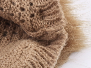 Detaillierte Makroansicht der kamelfarbenen Stricktextur und Kunstpelzbesatz am Kleid