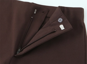 Detail der High-Waist-Hose mit Reißverschluss, passendem Knopf und silbernem Metallhaken
